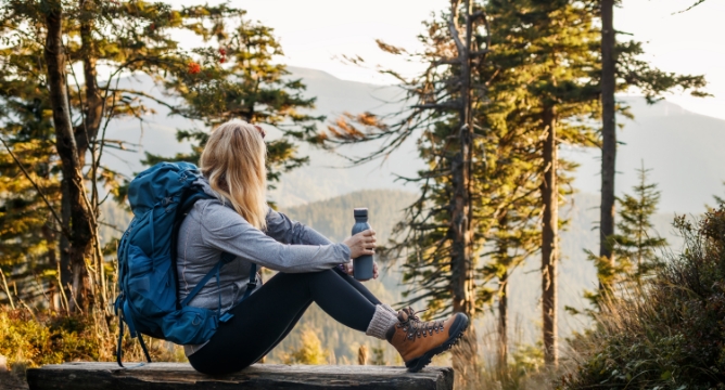 Picture of person sitting down on log in forest